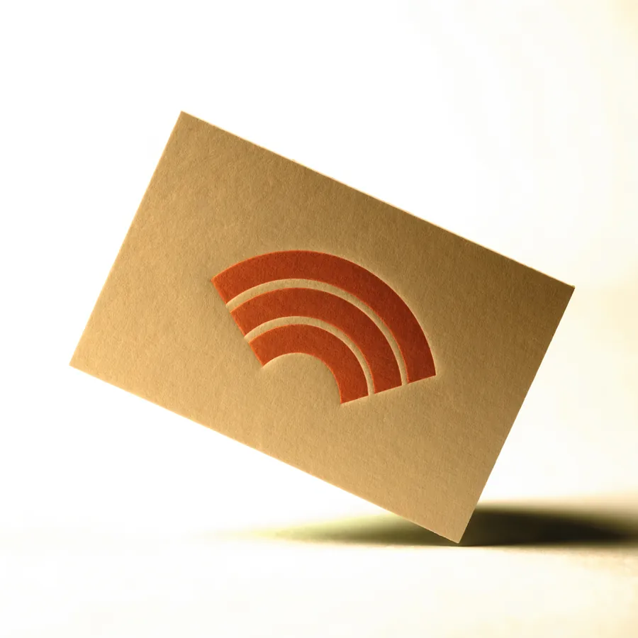 A cream Closr Tag with the contactless mark embossed at its centre